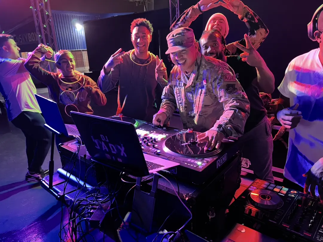 Benjamin Taitano, DJ Pillow Puff, scratching on Rane turntables in uniform while friends cheer